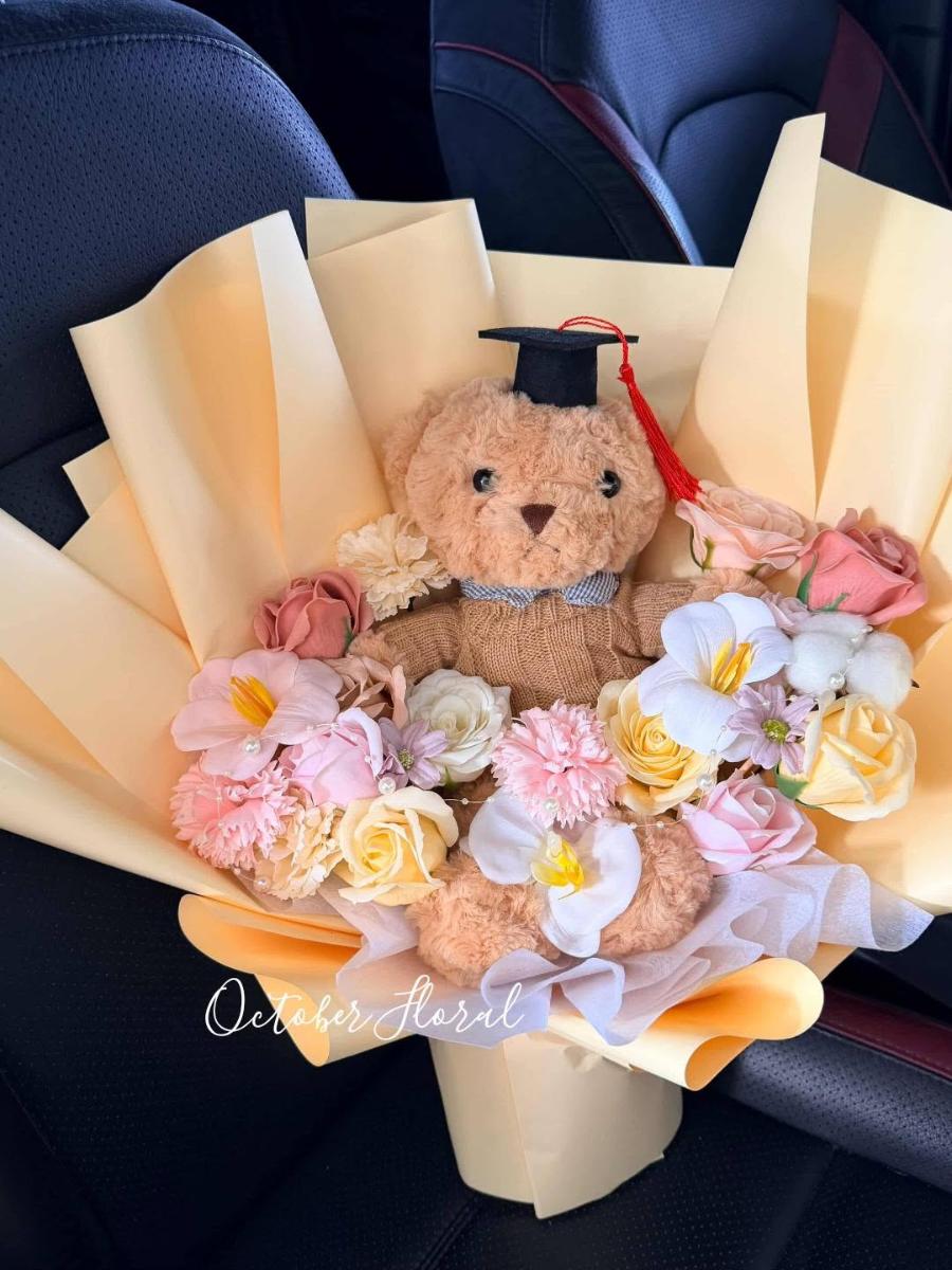 Warm Yellow Wrapped Graduation Bouquet with a Graduation-Capped Brown Plush Bear and Mixed Artificial Flowers