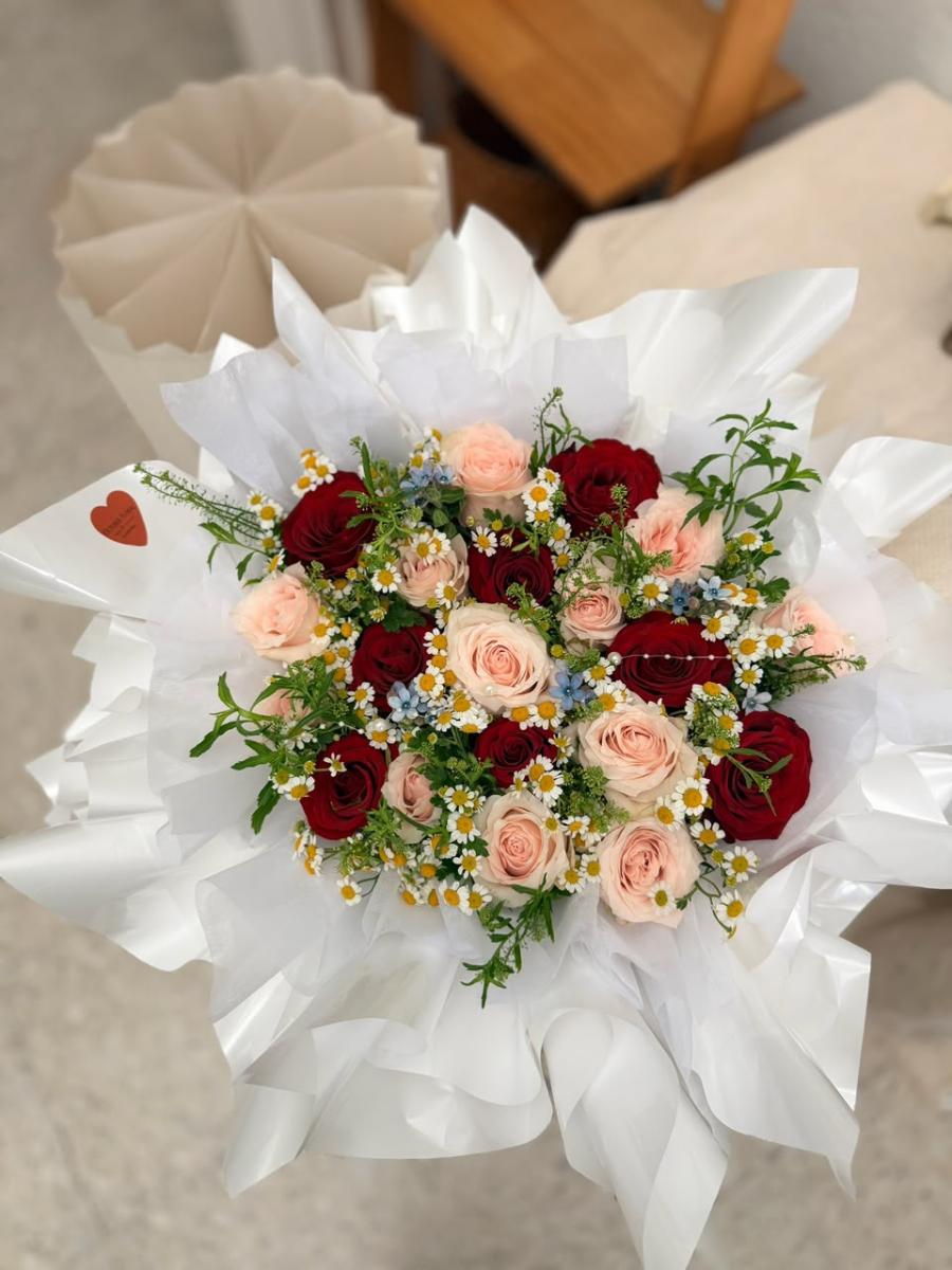Red & Pink Beauty - Hand-Tied Bouquet in White Multi-Layer Textured Packaging Featuring Red Roses, Champagne-Pink Roses, Small Daisies, and Green Foliage