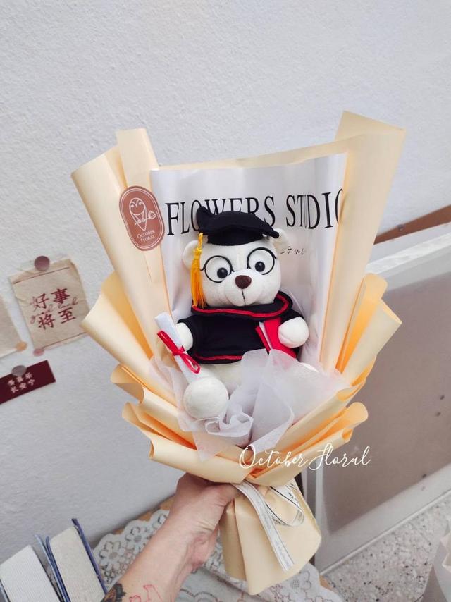 Warm Yellow Wrapped Graduation Bouquet Featuring a White Bear in Black-Rimmed Glasses and Graduation Cap